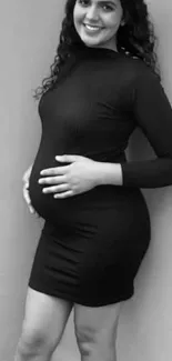 Black and white portrait of a woman in a black dress posing confidently.