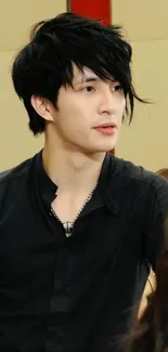 Stylish young person with black hair and a modern outfit.