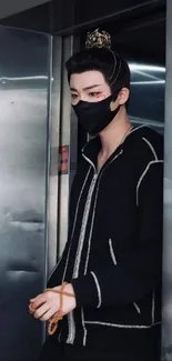 A masked person in stylish black attire emerges from an elevator.