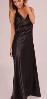 Elegant black satin dress with intricate strap details.