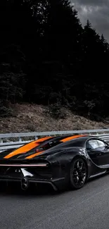 Black sports car with orange stripes on the road.