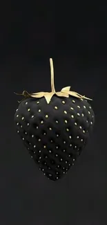 Black strawberry with gold accents on a dark background.