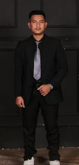 Man in black suit against dark background with stylish look.