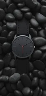 A sleek black watch on dark pebbles, minimalist elegance.