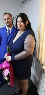 Couple in elegant blue attire indoors.