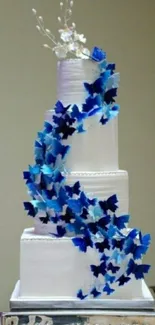 White tiered cake with cascading blue butterflies on silver stand.