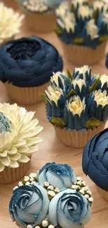 Blue and cream floral cupcakes on wood tray.