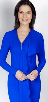 Woman in a cobalt blue dress posing elegantly against a neutral background.