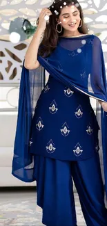 Woman in elegant blue ethnic dress with intricate designs.