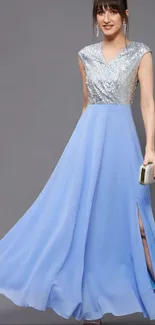 Elegant blue gown with shimmering silver top on a graceful woman.