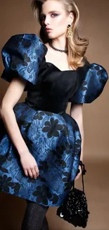 Elegant woman in blue floral gown posing against brown background.