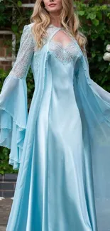 Elegant woman in sky blue gown standing in a garden.