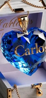 Elegant blue heart crystal pendant with golden lettering in a box.