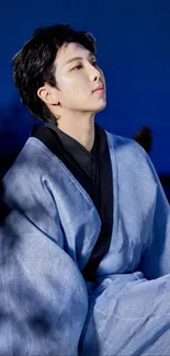 Person wearing a blue kimono against a twilight sky.