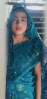 Young woman in teal blue saree, serene portrait.