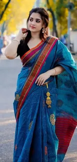 Portrait of a woman in a blue saree with golden accents.