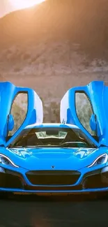 Blue sports car with scissor doors open against mountain backdrop.