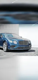 Elegant blue sports car parked on stone pavement.