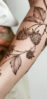 Intricate blackberry botanical tattoo on arm.