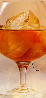 Luxurious brandy glass with ice cubes, rich amber color.