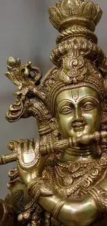 Ornate brass sculpture of Krishna playing a flute, perfect for mobile wallpaper.