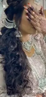 Bride with intricate henna and elegant jewelry wearing a traditional outfit.