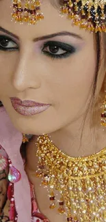 Close-up of an Indian bride in gold jewelry with intricate mehndi design.