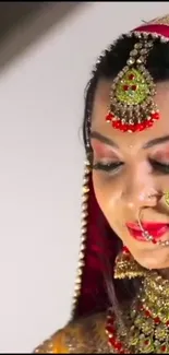 Elegant bride with red and gold jewelry in a traditional portrait.