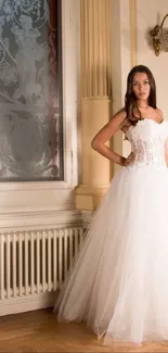 Bride in a classic white gown stands in an elegant room setting.