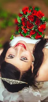 Bride holding red roses in beautiful outdoor setting.