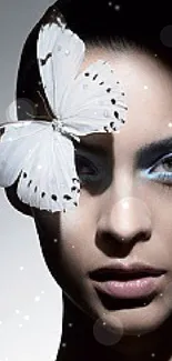 Portrait with delicate white butterfly and blue eyeshadow.