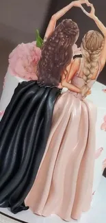 Elegant cake topper featuring two friends in detailed dresses.