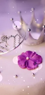 Elegant white cake with crowns and a purple flower decoration.