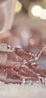 Elegant rose gold candles with soft snow background.