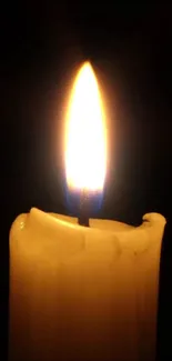 Mobile wallpaper featuring a warm candle flame glowing in the dark.