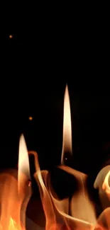 Two soft candle flames against a dark backdrop.