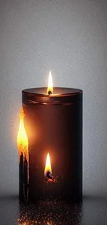 Elegant candle glowing with soft light against a grey background.