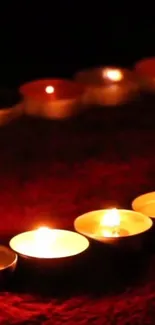 Mobile wallpaper showing glowing candles on a dark red background.