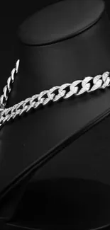 Silver chain elegantly displayed on a black stand.