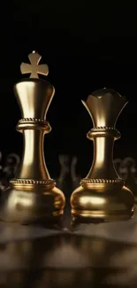 Golden chess pieces on a dark background, king and queen in focus.