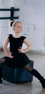 Child in ballet pose inside dance studio.