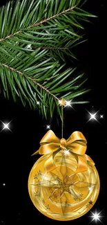 Gold Christmas ornament on pine branch with black background.