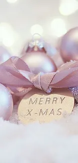 Pastel Christmas ornaments with ribbon on snow.