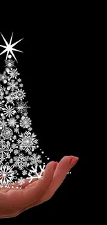 Elegant artwork of a Christmas tree above a hand on a black background.