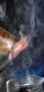 Close-up of a lit cigar with swirling smoke and vibrant flame.