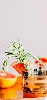 Elegant setup of citrus drinks with rosemary in warm tones.