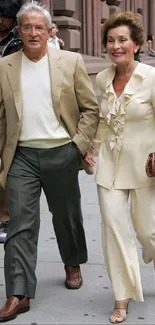 Stylish couple walking in city street, dressed elegantly.