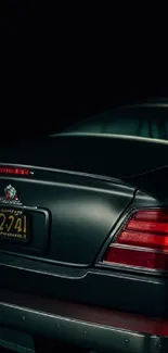 Classic car with red taillights under moody lighting.