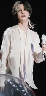 Elegant performer on stage with a microphone.