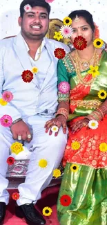 Elegant couple seated in vibrant attire on decorative couch during celebration.